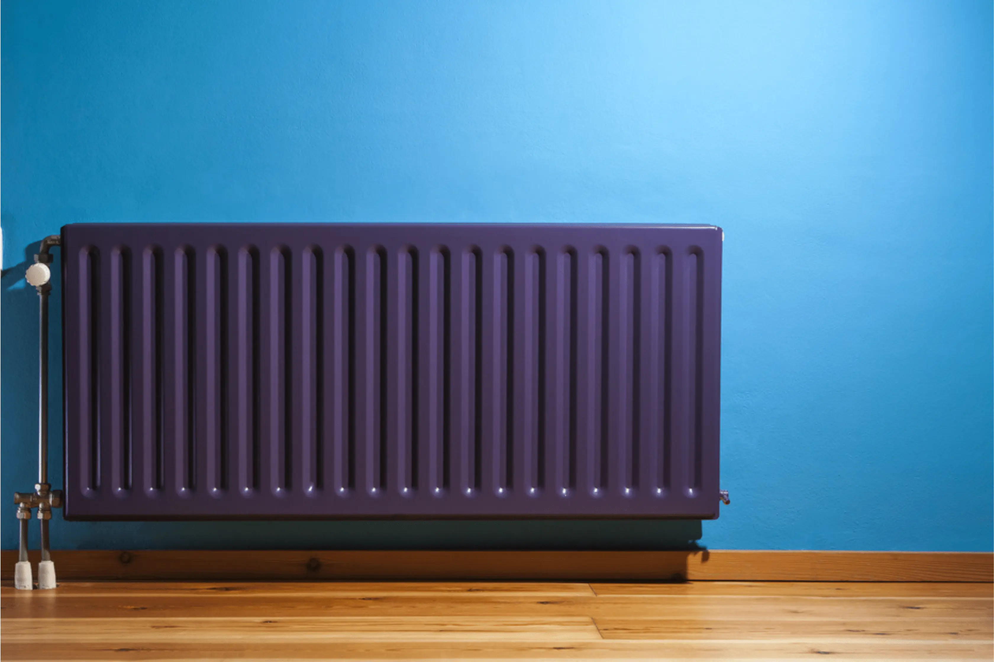 Purple Coloured Radiator Propped Up Against Blue Wall